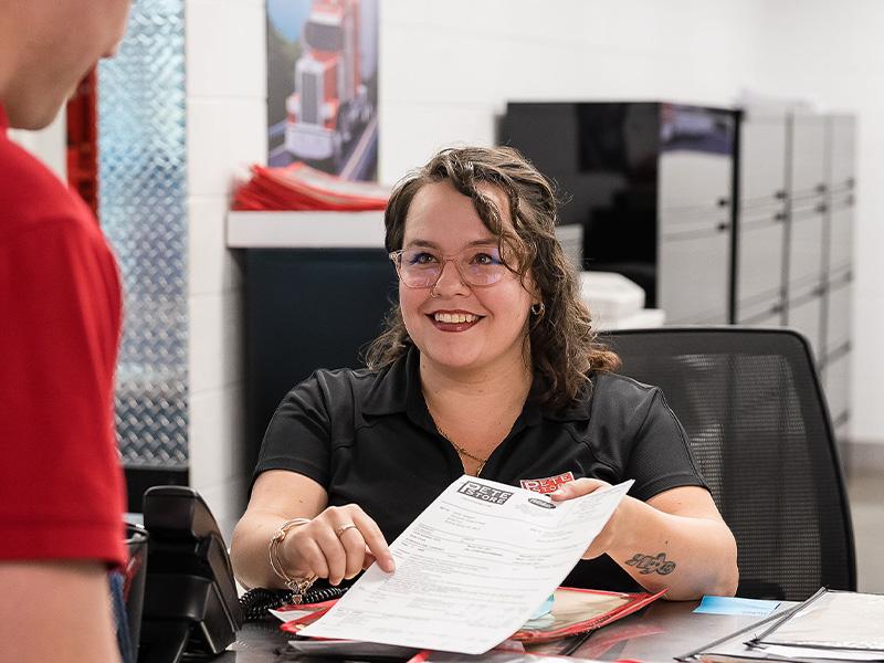 A Pete Store service advisor showing a semi truck repair bill to a customer